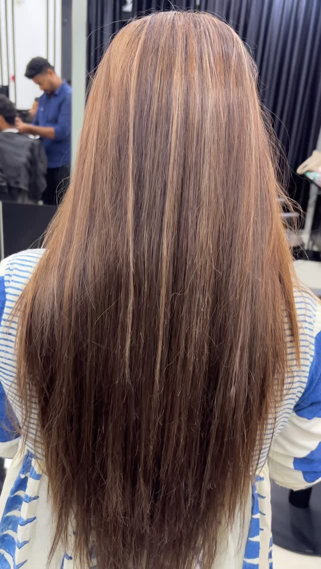Lighter highlights through long hair with a darker base, from RAM KALASAPATI's salon work
